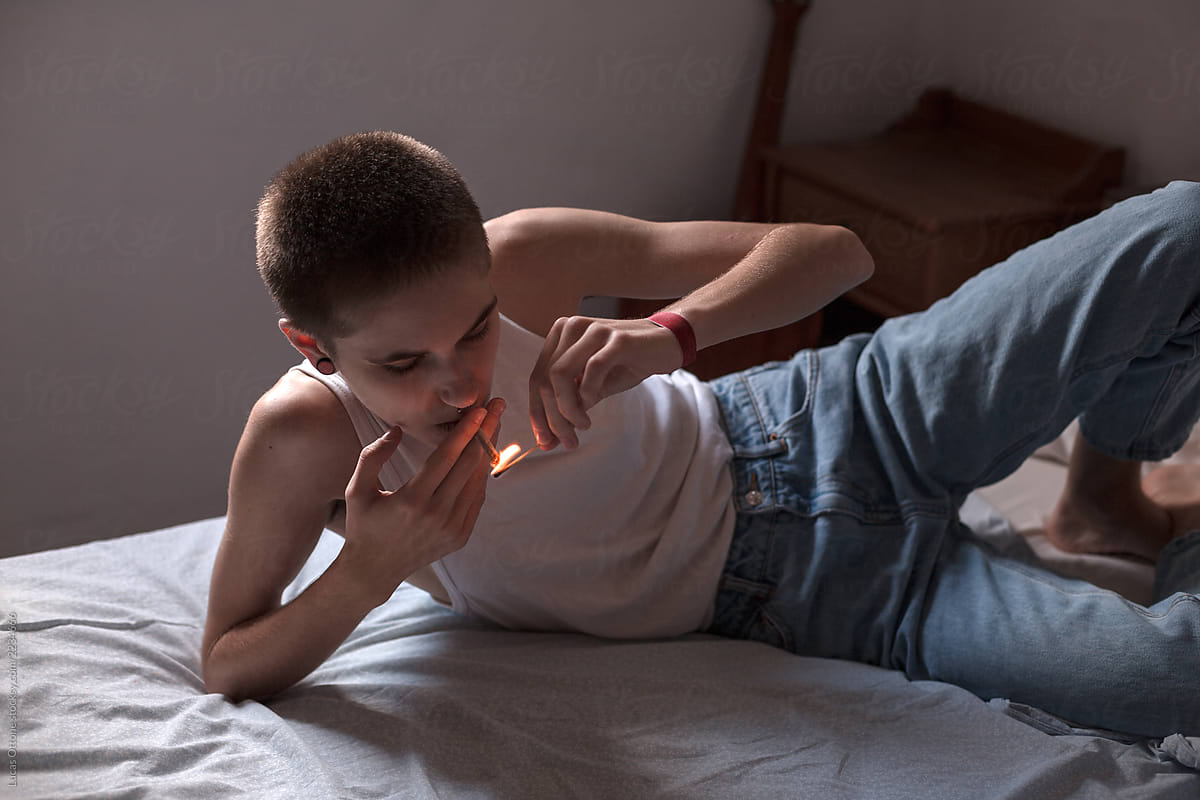 Lighting A Cigarette In Bed By Stocksy Contributor Lucas Ottone