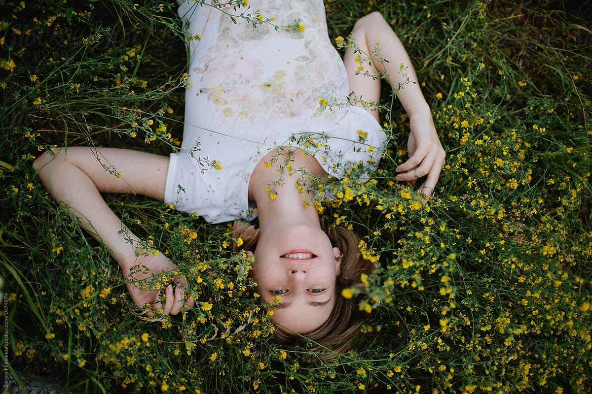 Charming Woman Lying In Field Flowers By Stocksy Contributor Sergey