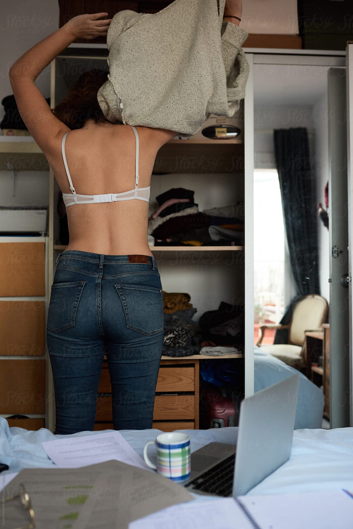 Woman Taking Off Her Sweater In Bedroom By Stocksy Contributor Guille Faingold Stocksy