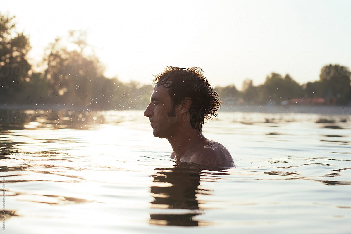 Man Taking A Bath In A Lake On Sunset Del Colaborador De Stocksy Blue Collectors Stocksy