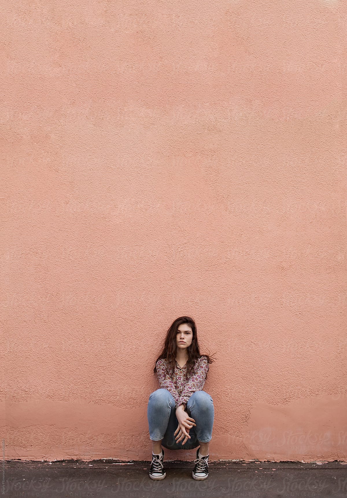Stylish Teen Girl Sitting Near Wall By Stocksy Contributor Sergey Filimonov Stocksy