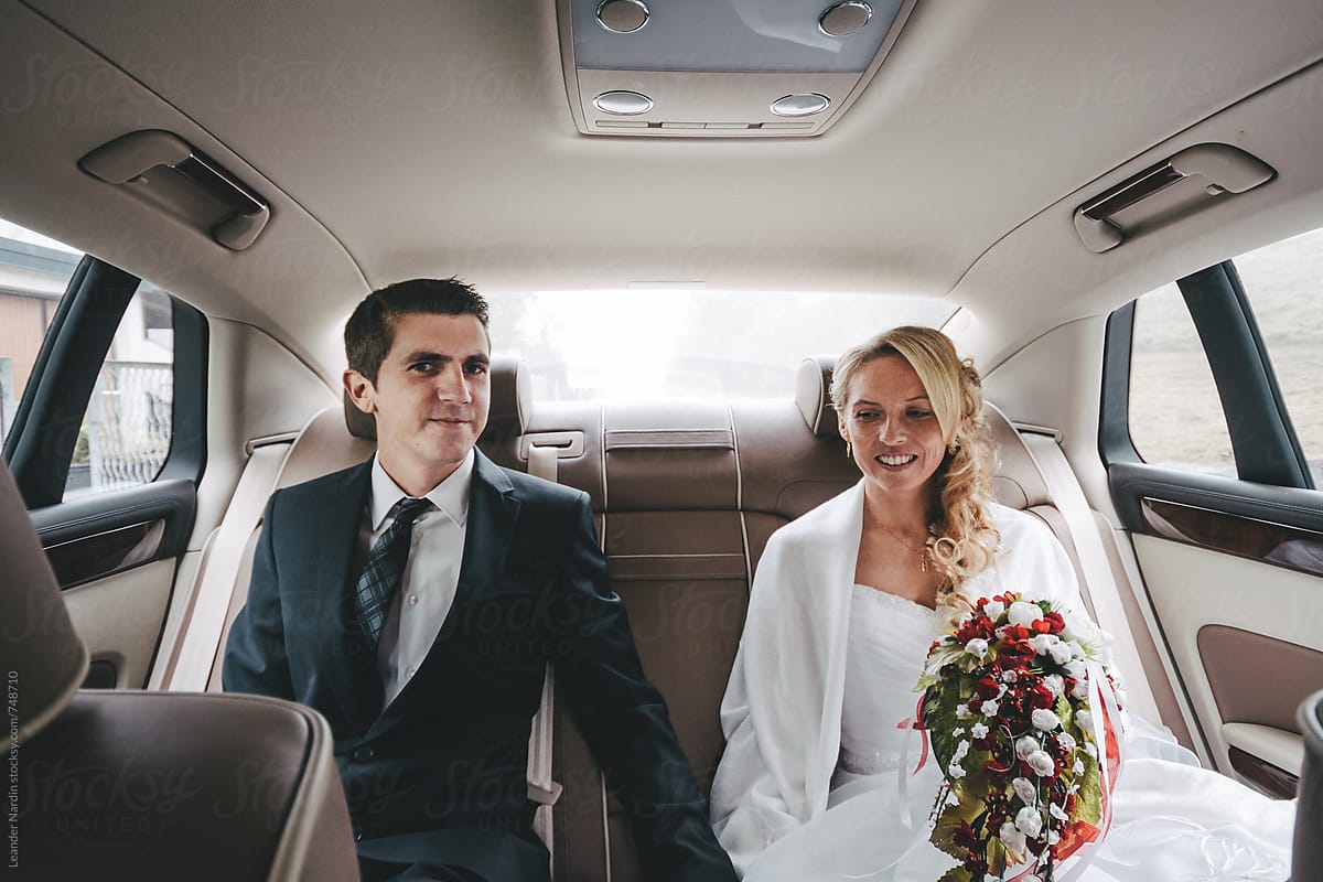 Bridal Couple On The Backseat Of A Wedding Car By Stocksy Contributor