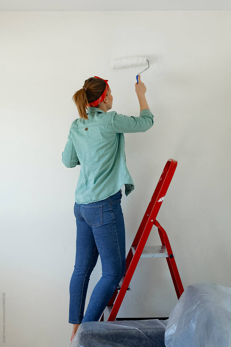Woman painting wall during home renovation