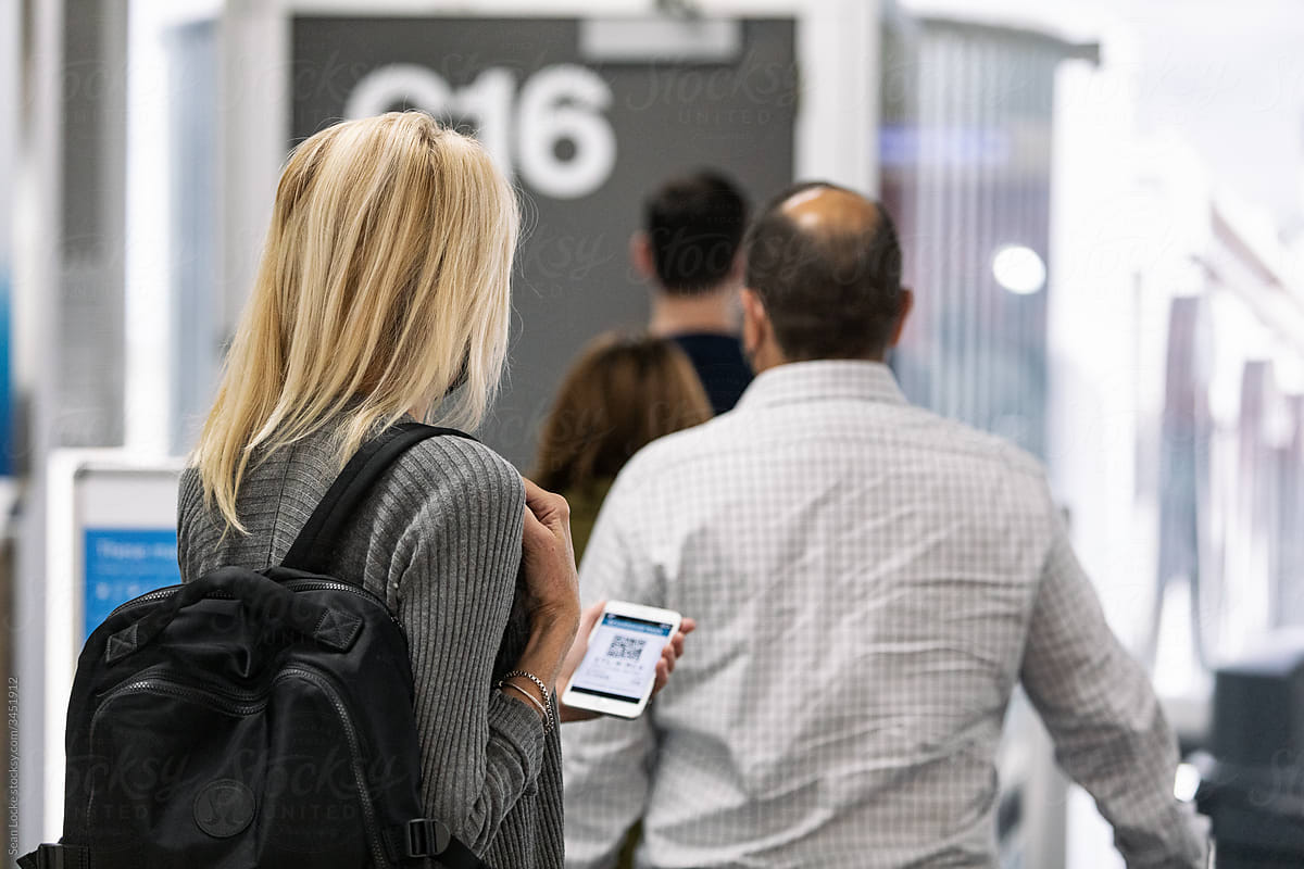 Travel: Woman Checks Flight Info While Waiting In Line At Gate
