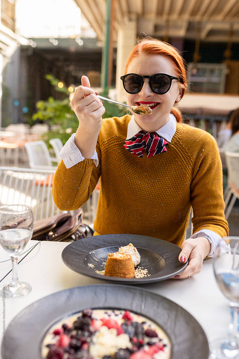 Smiling woman enjoying the dessert in restaurant