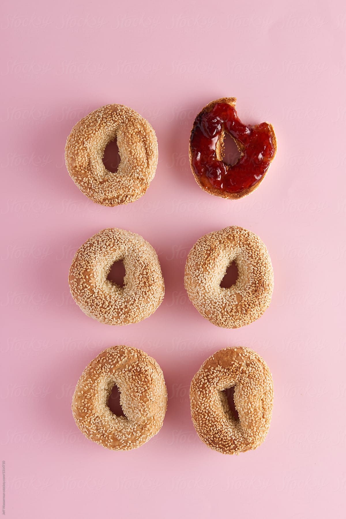 Sesame Seed Bagels on Pink with One Toasted with Jam