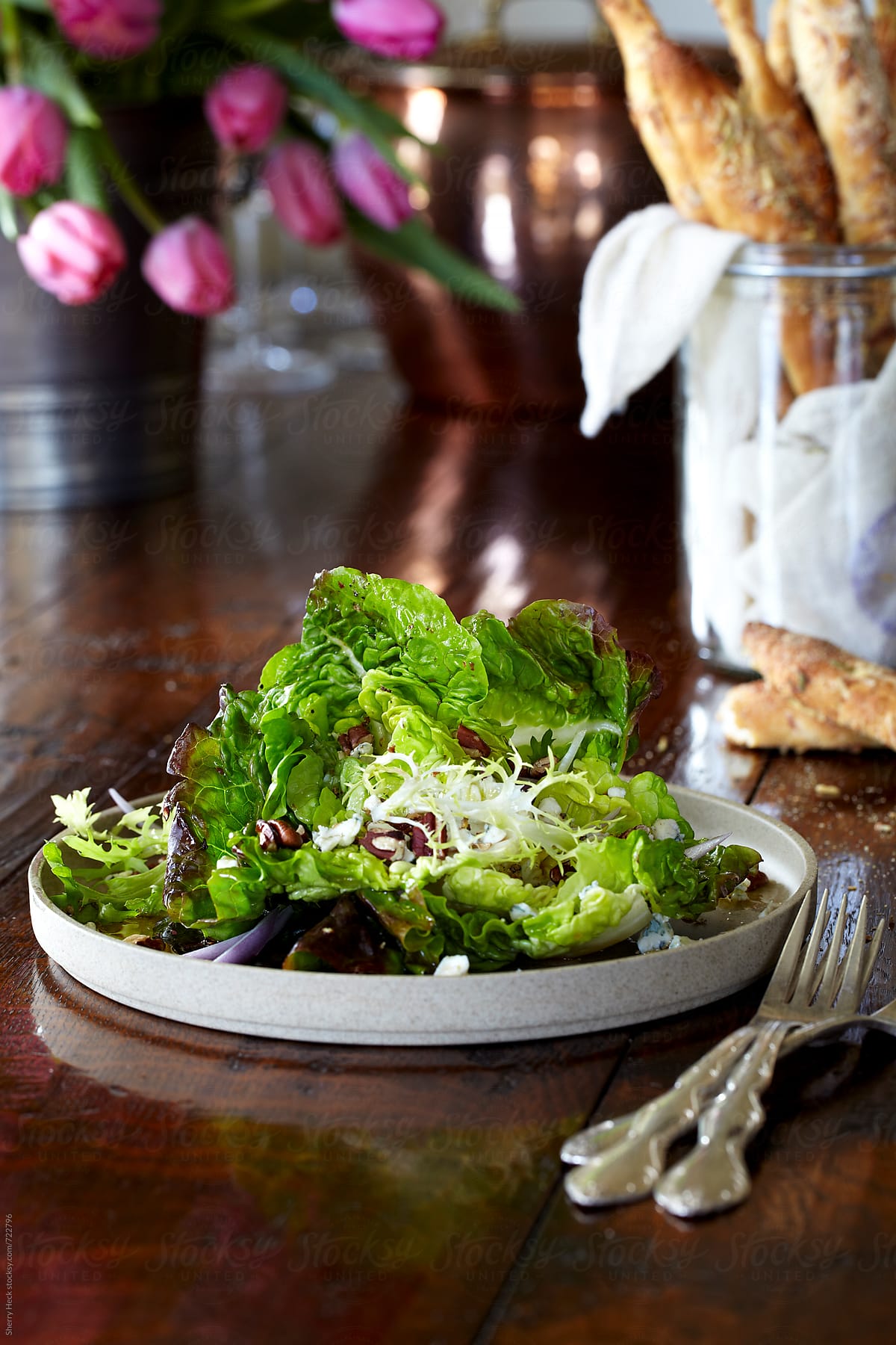 Plate of fresh bib lettuce salad on elegant wood table