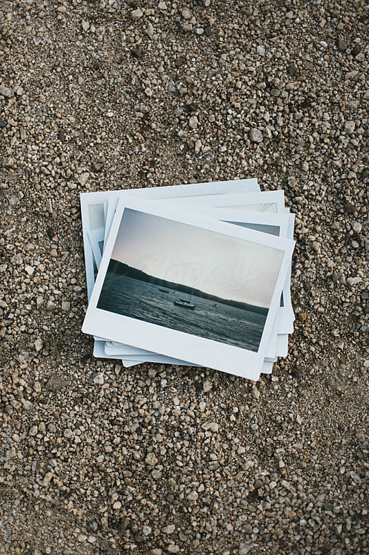 stack of instant photos from road trip on ground