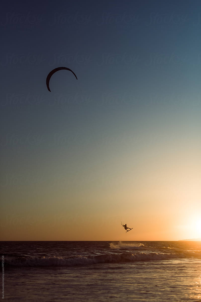 Kitesurfer flying at sunset