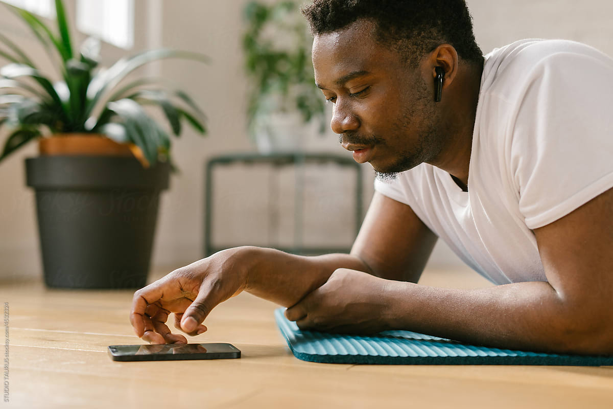 Fit man using cellphone between workouts