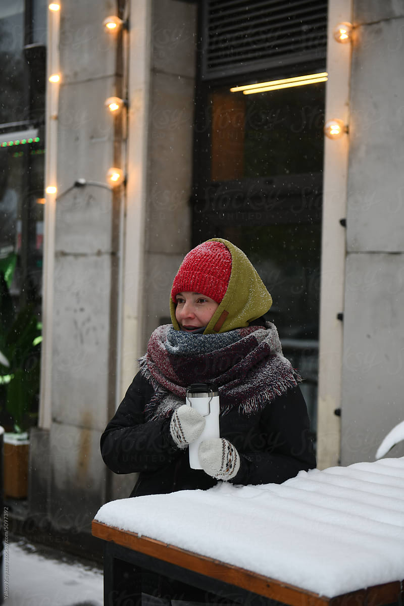 woman drinking coffee outside. wintertime streets