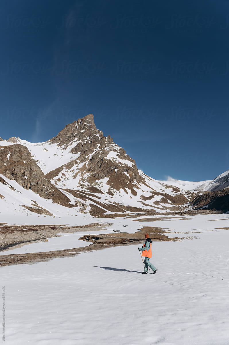 Unrecognizable traveler walking near snowy mountains