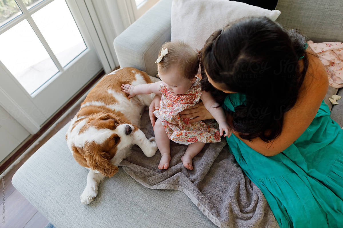 A baby girl and mother with a dog