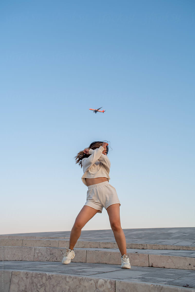 Dancer at sunset with a plane in the sky travel concept