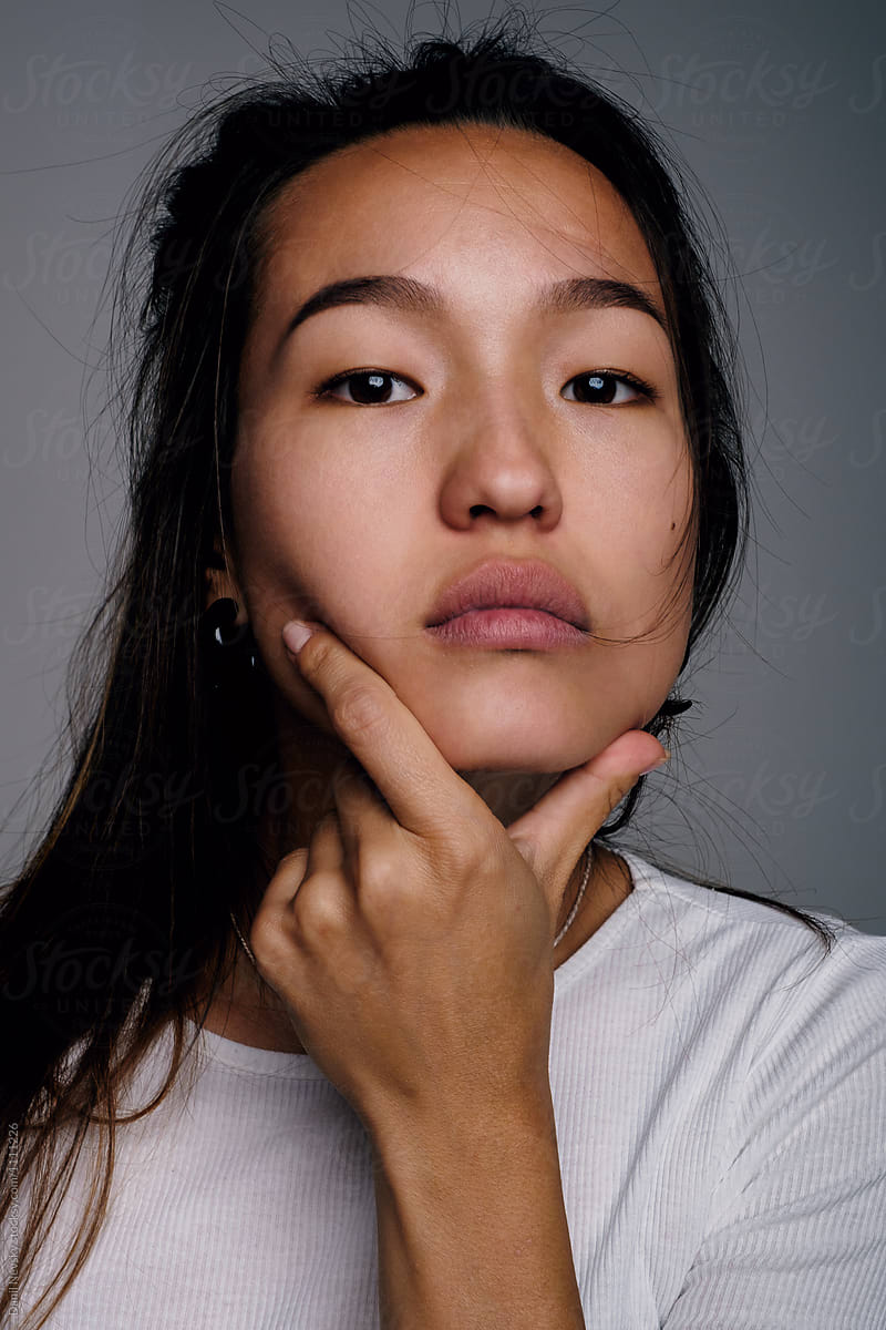 Asian woman with hand on chin
