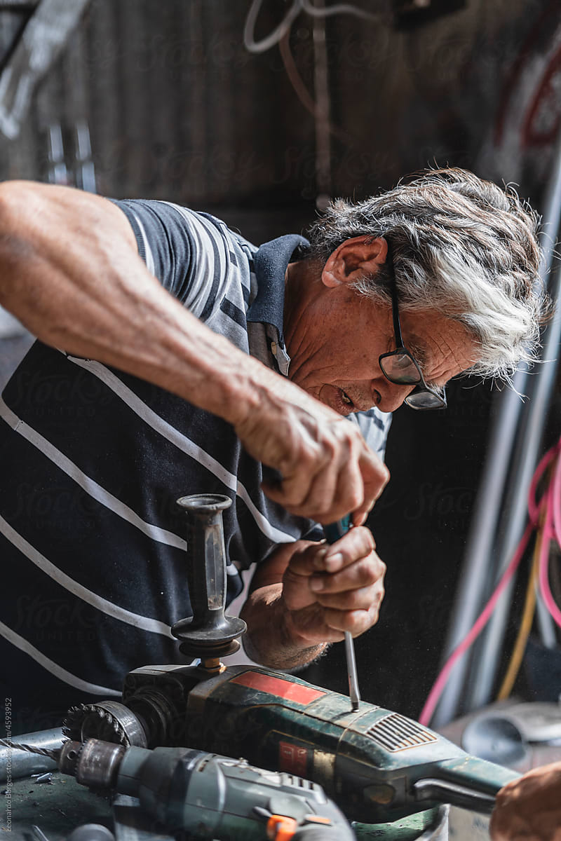Older man repairing a machine