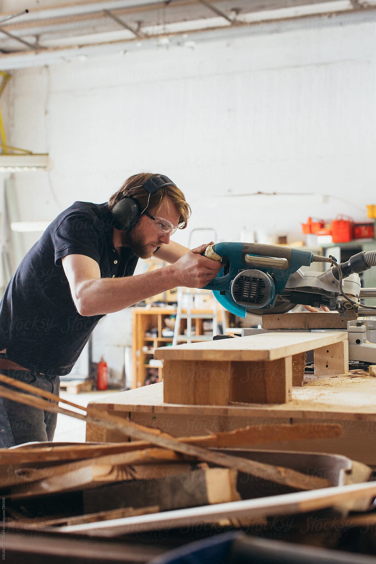 Male Carpenter Using Circular Saw in Bright Workshop