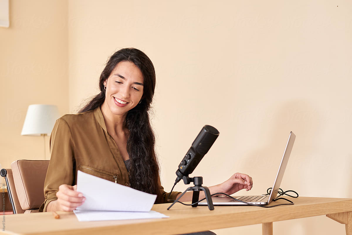 Positive woman reading notes for podcast