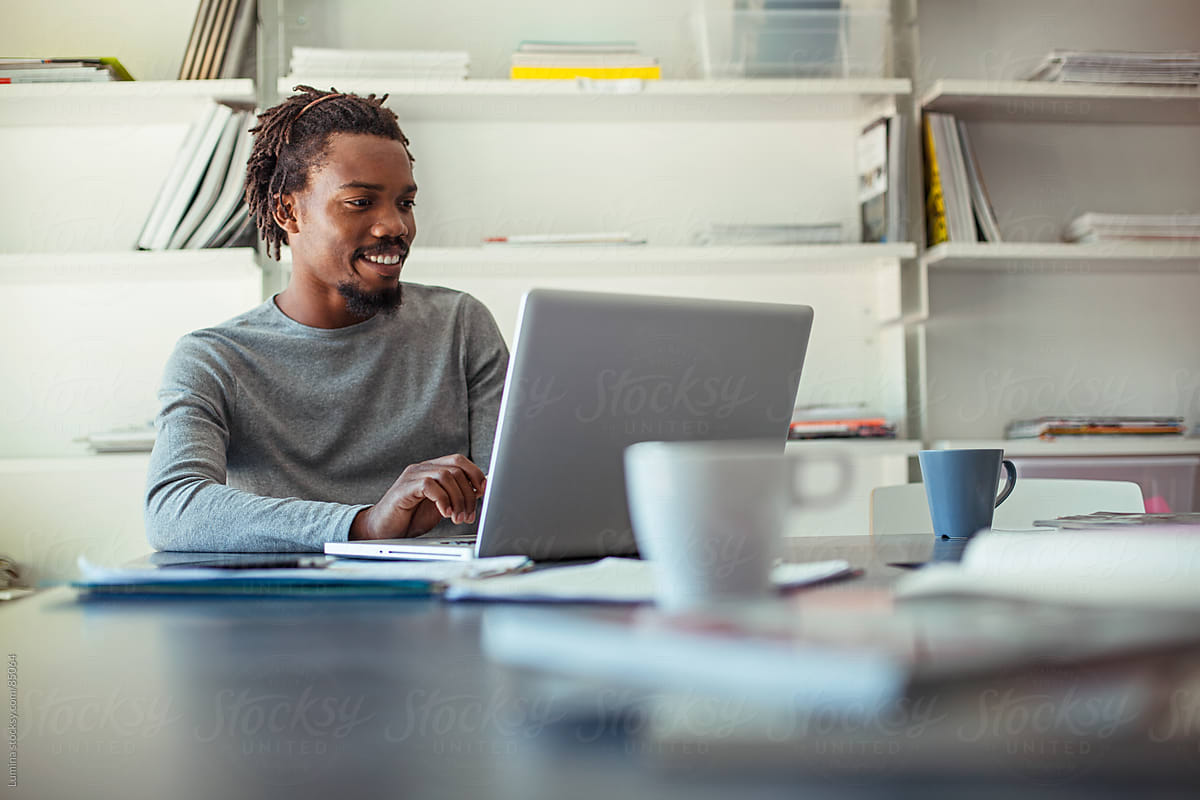 Smiling African Businessman Working at His Laptop