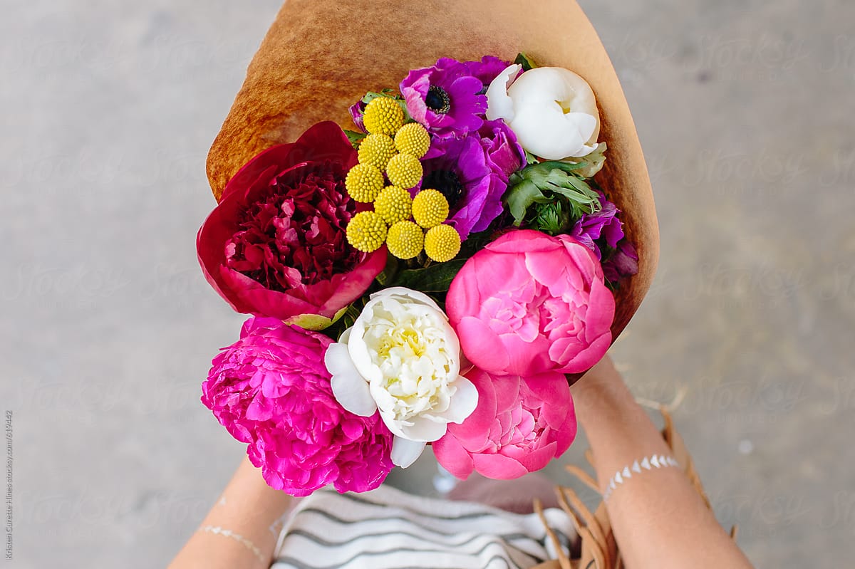 Someone holding a vibrant flower arrangement from the flower market