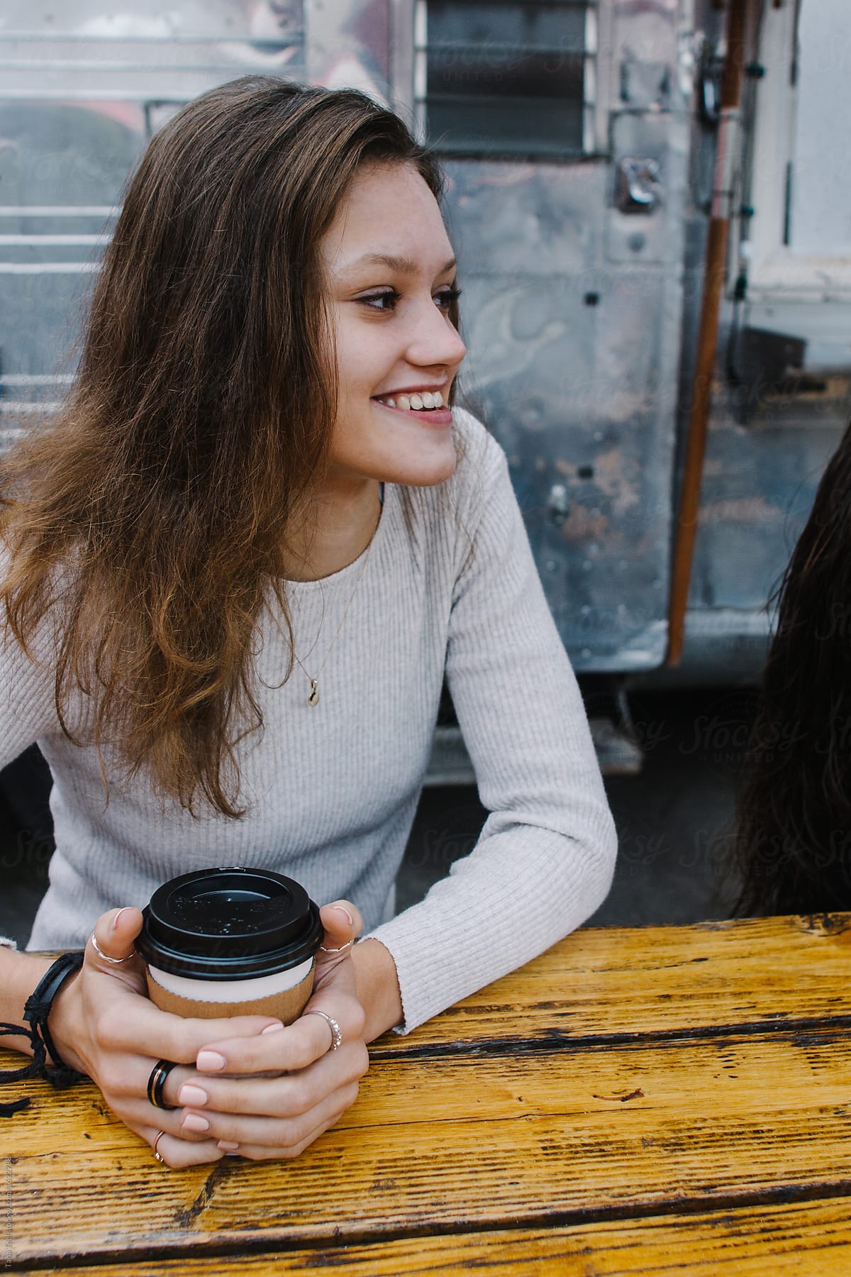 young woman enjoys coffee at outdoor venue