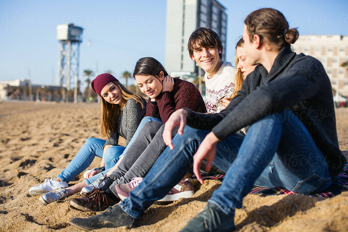«teenage Friends Hanging Out Sitting On The Beach Del Colaborador De