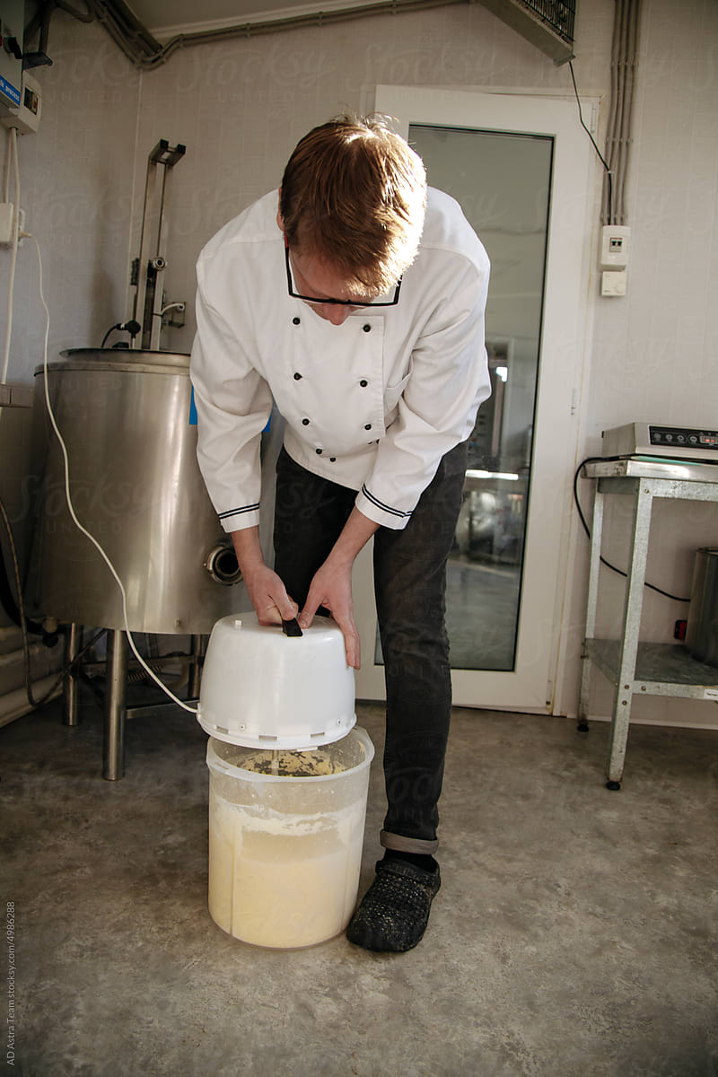 A cheese maker whips butter in a cheese factory