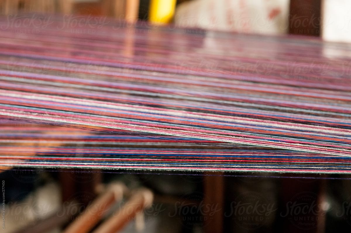 Cotton threads passing through a traditional wooden loom machine