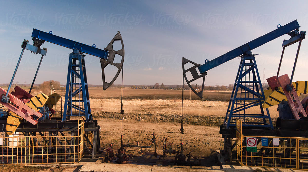 Oil pumpjacks over wells in evening