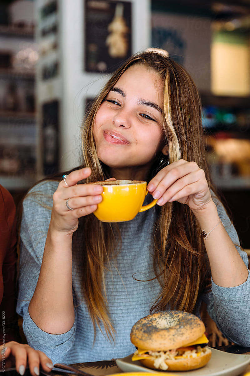 Young woman enjoying cappuccino in cafe