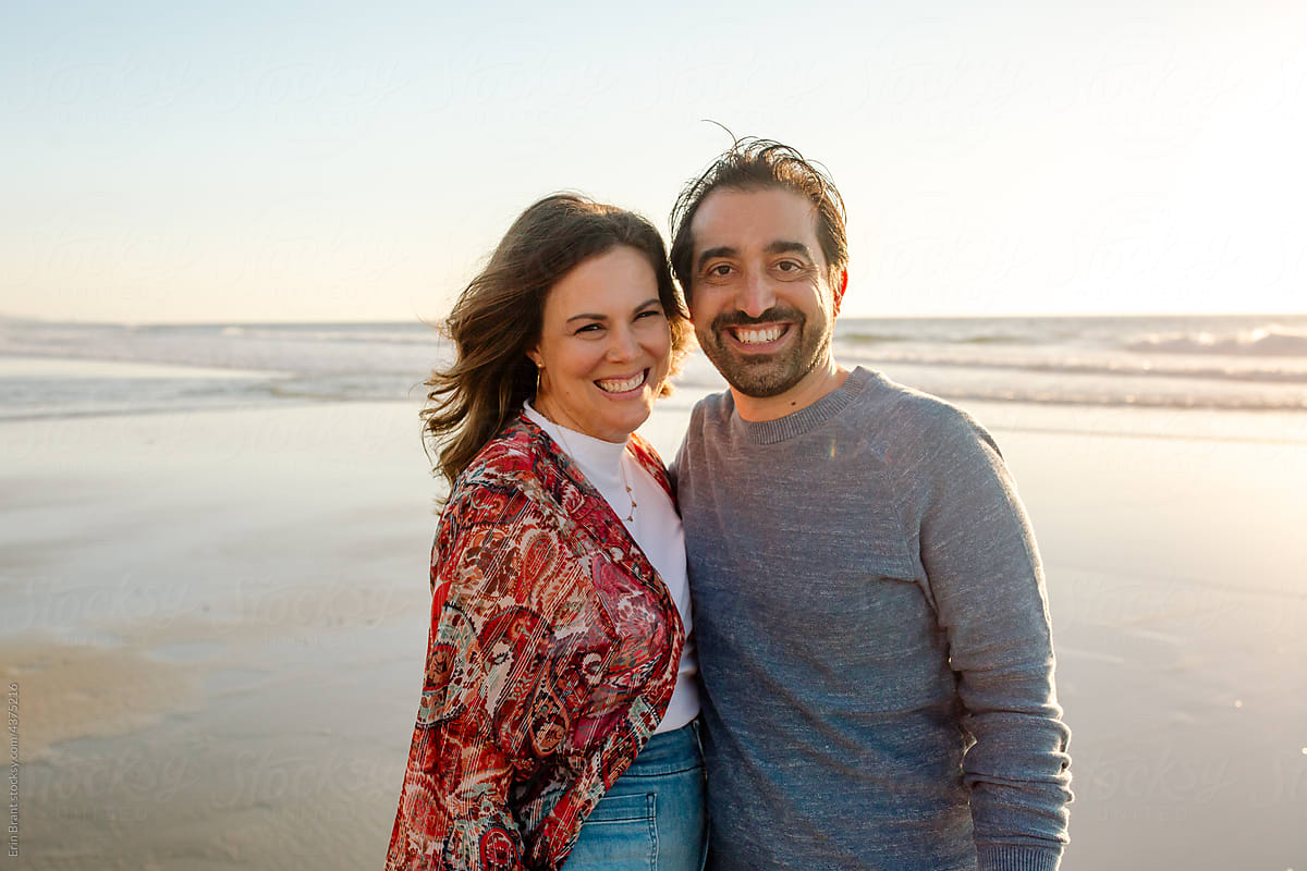 Joyful couple on beach at sunset
