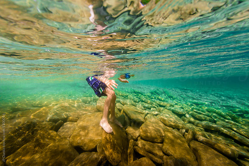 Boy Looking Underwater In Crystal Clear Summer Lake