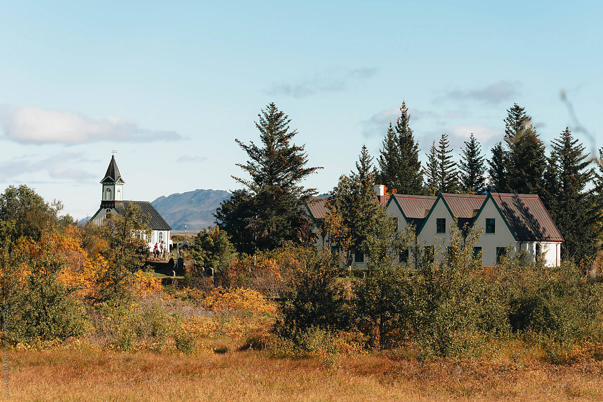 Scenic rural landscape. Houses, church along autumn trees in mountain