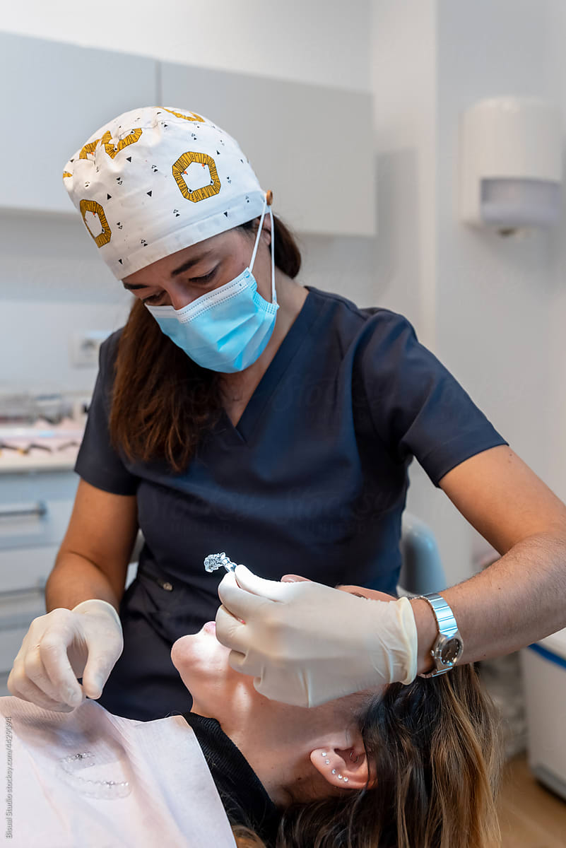 Female dentist putting invisible orthodontics to client