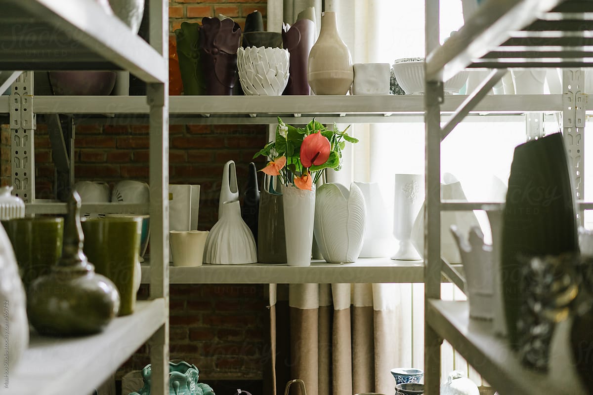 Shelf with empty vases and bouquet of flower