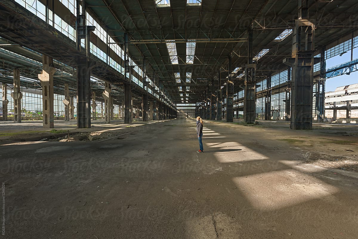 Woman standing on the middle of abandoned warehouse