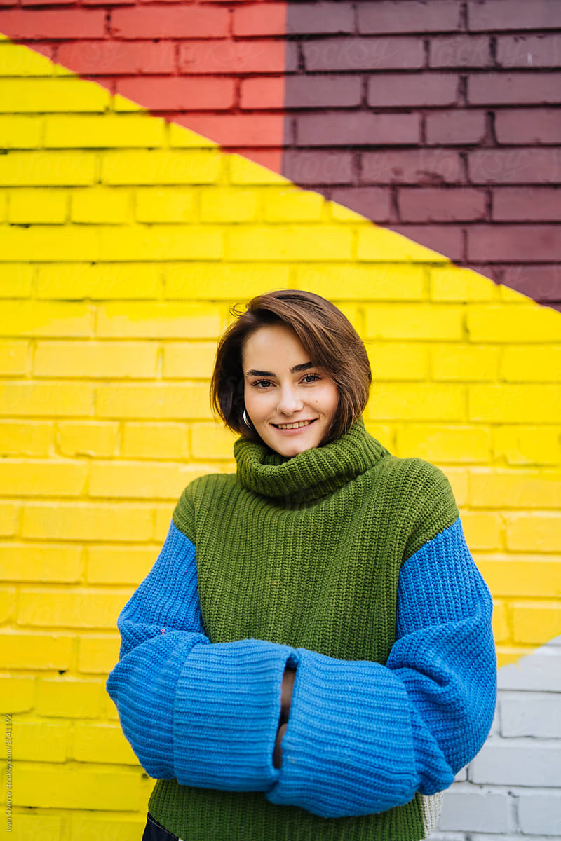 smiling beauty against the background of a colorful wall