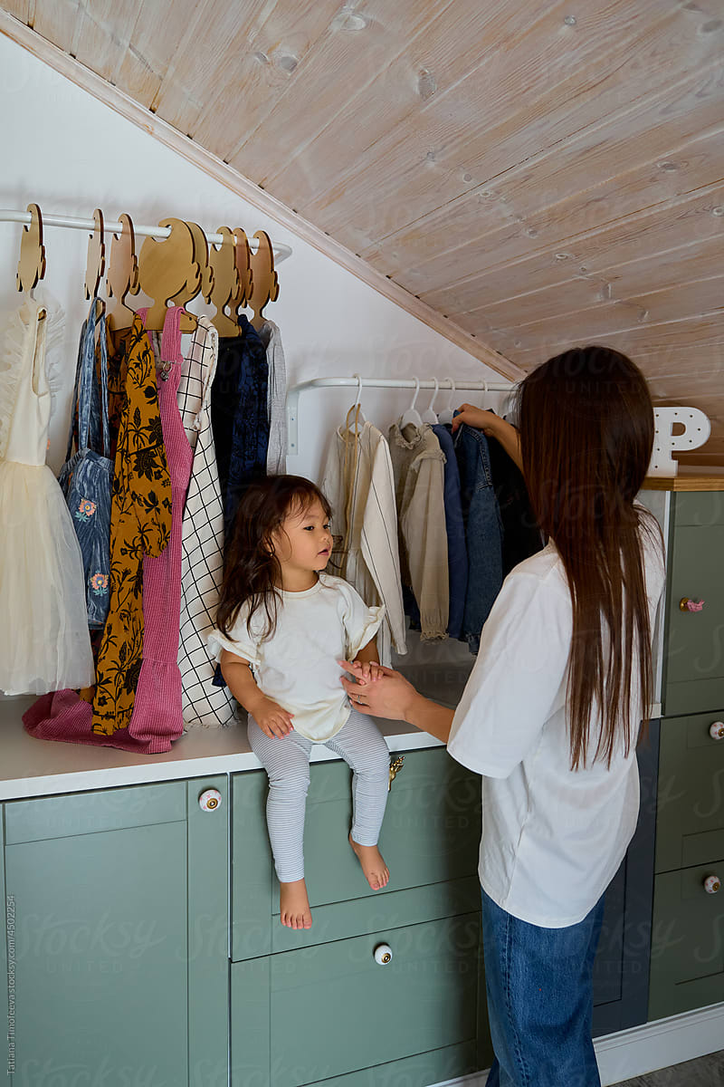 mom and daughter choose clothes in the dressing room