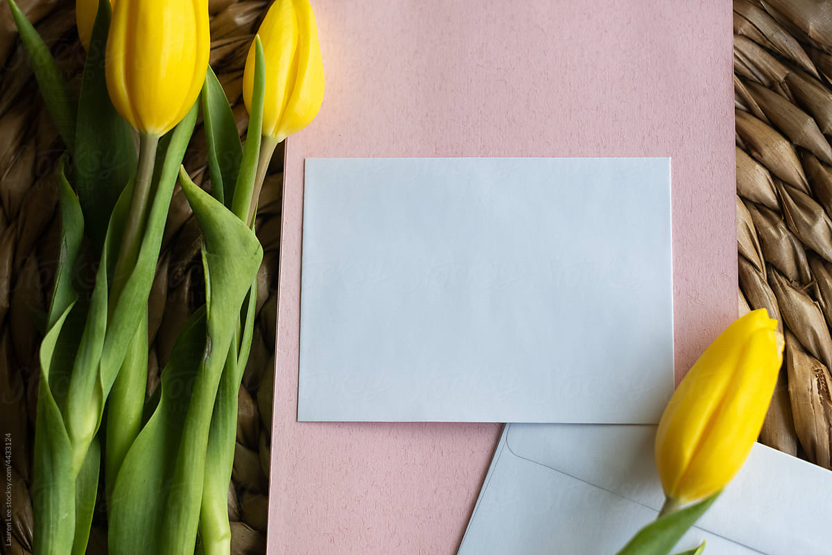 Yellow tulips and pink stationery