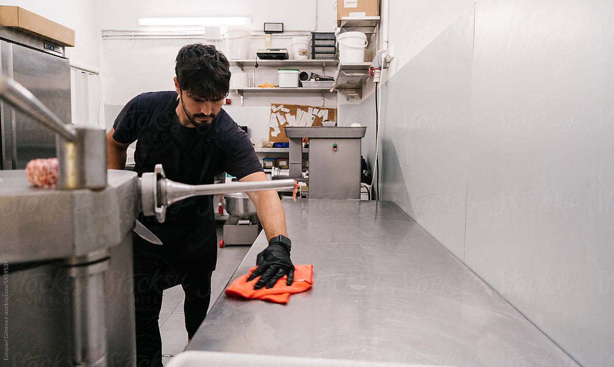 Male worker grinding meat in kitchen in butchery