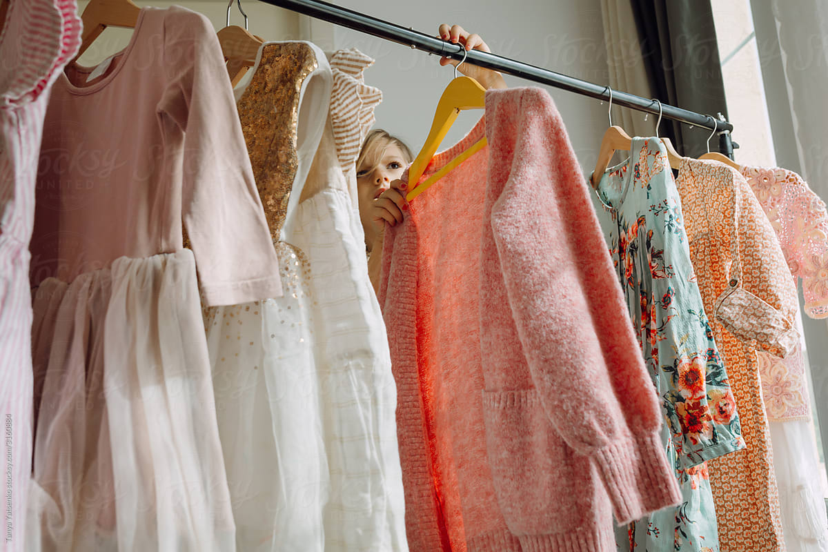 Girl choosing dresses on a clothing rack