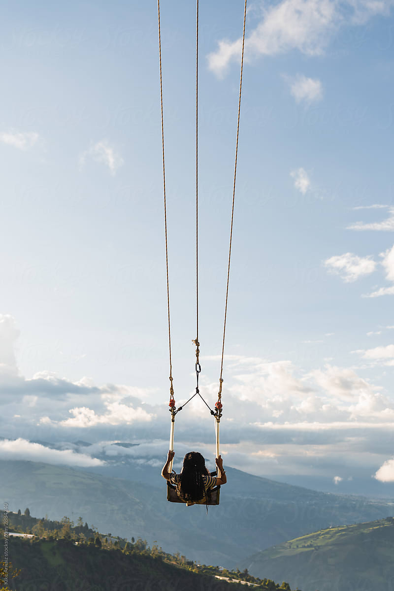 Girl swinging with mountains in the background