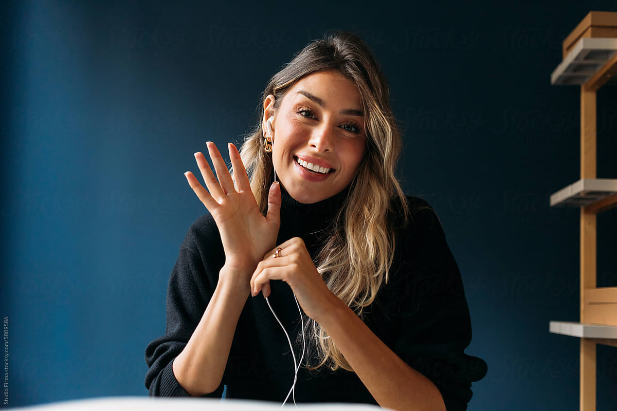 Woman at desk waving