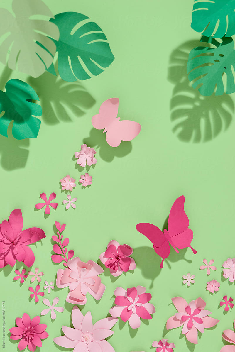 Pink paper flowers on green background. Cut from paper.