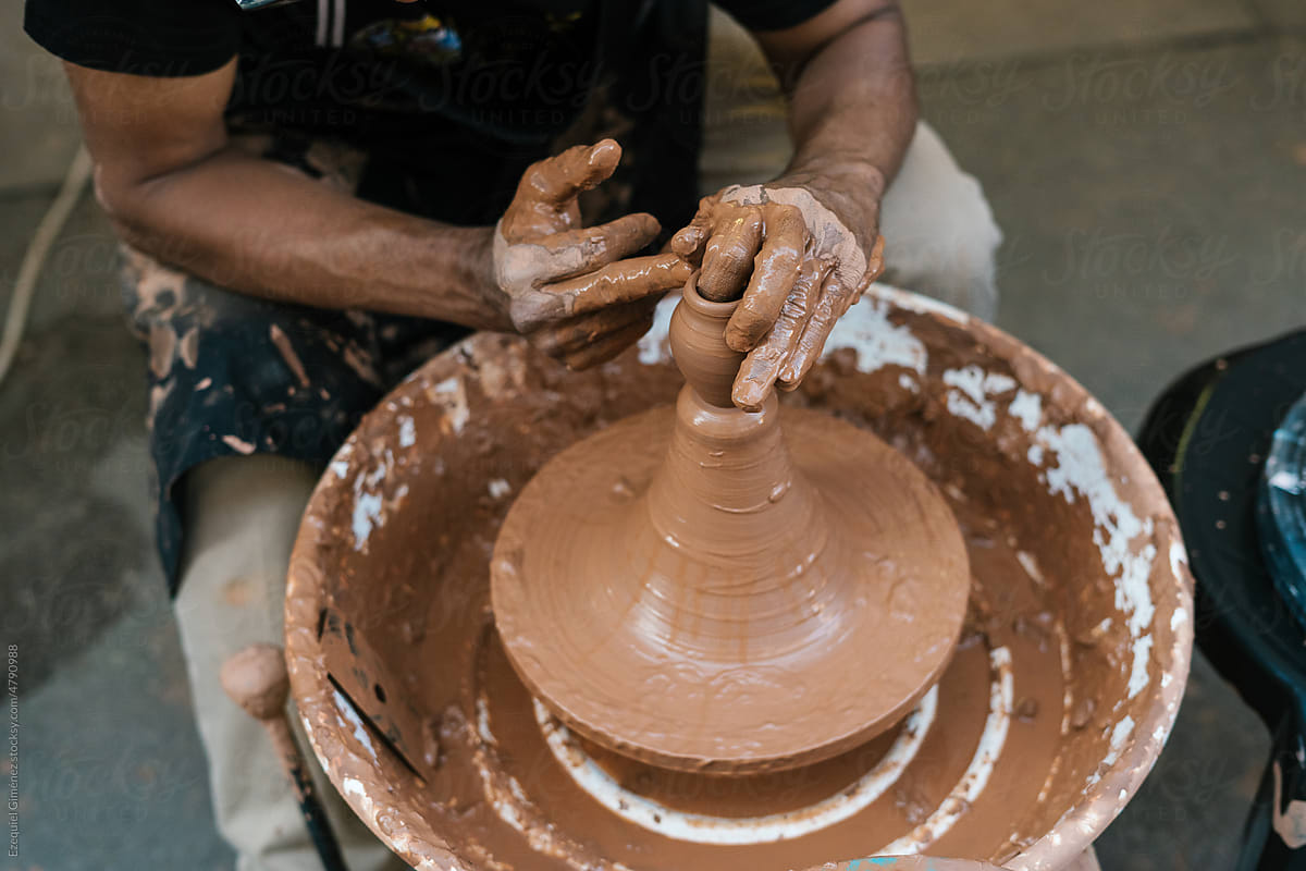 Unrecognizable man making clay vessel