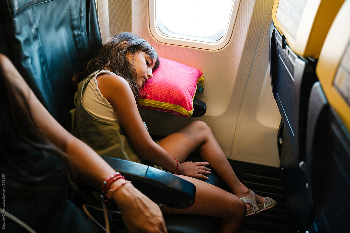 Sleeping girl in airplane near mother