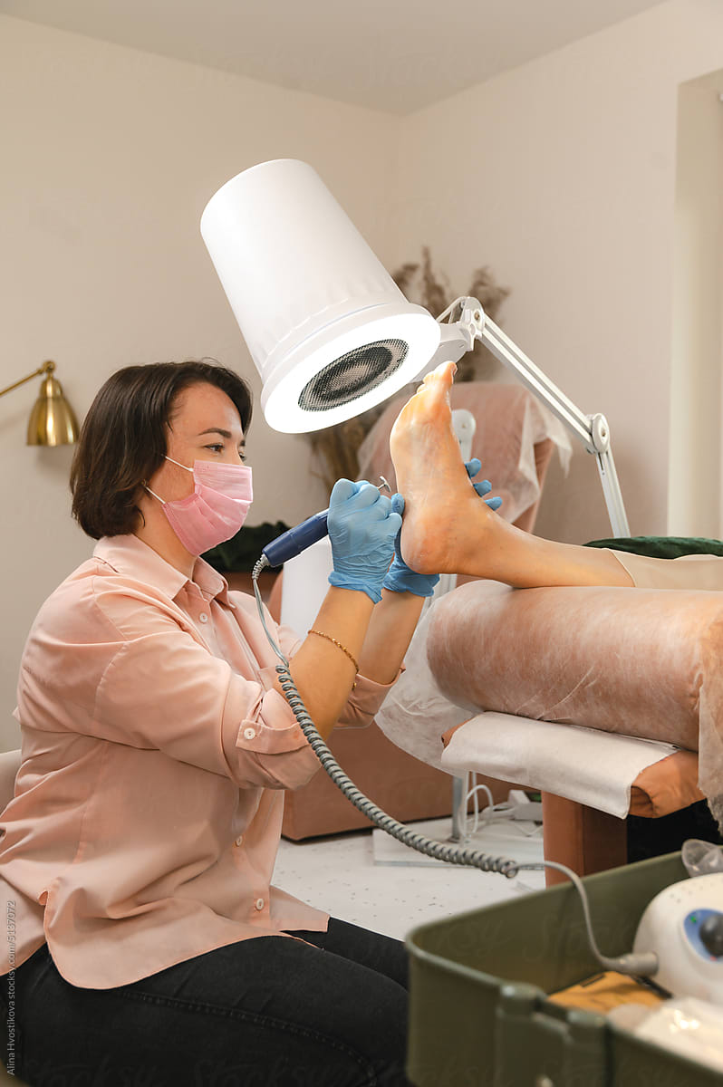 Beautician doing procedure on clients feet