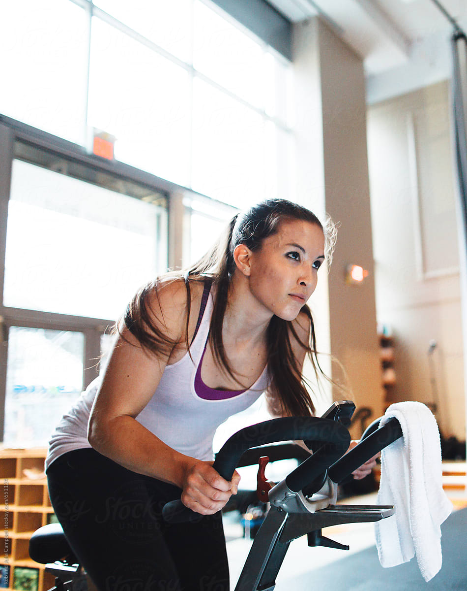 Young woman working hard during spin cycle class