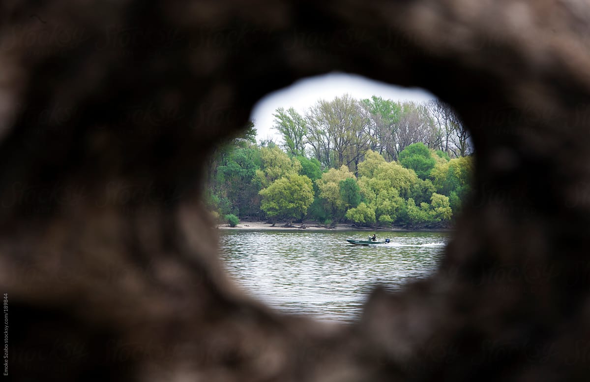 A boat seen through an almost circular tree hole