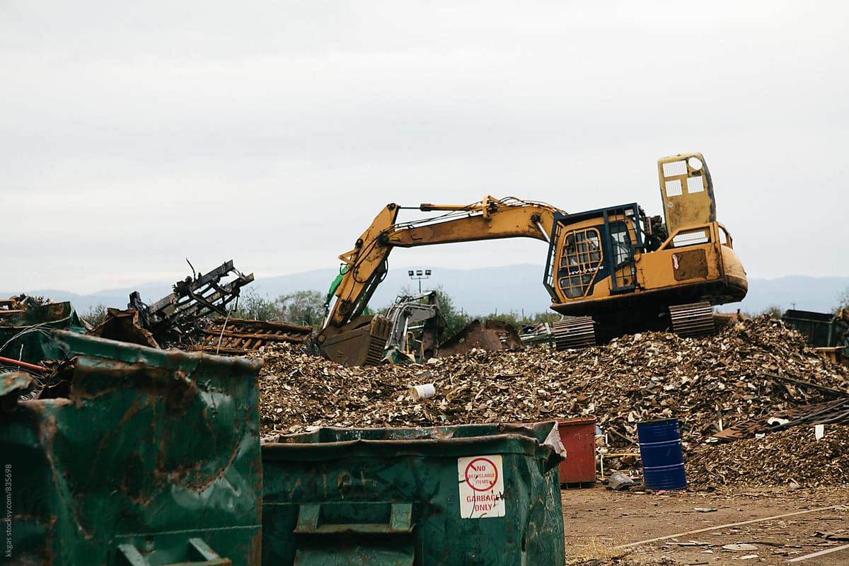 Excavator sorting out metal for recycling at a recycling centre